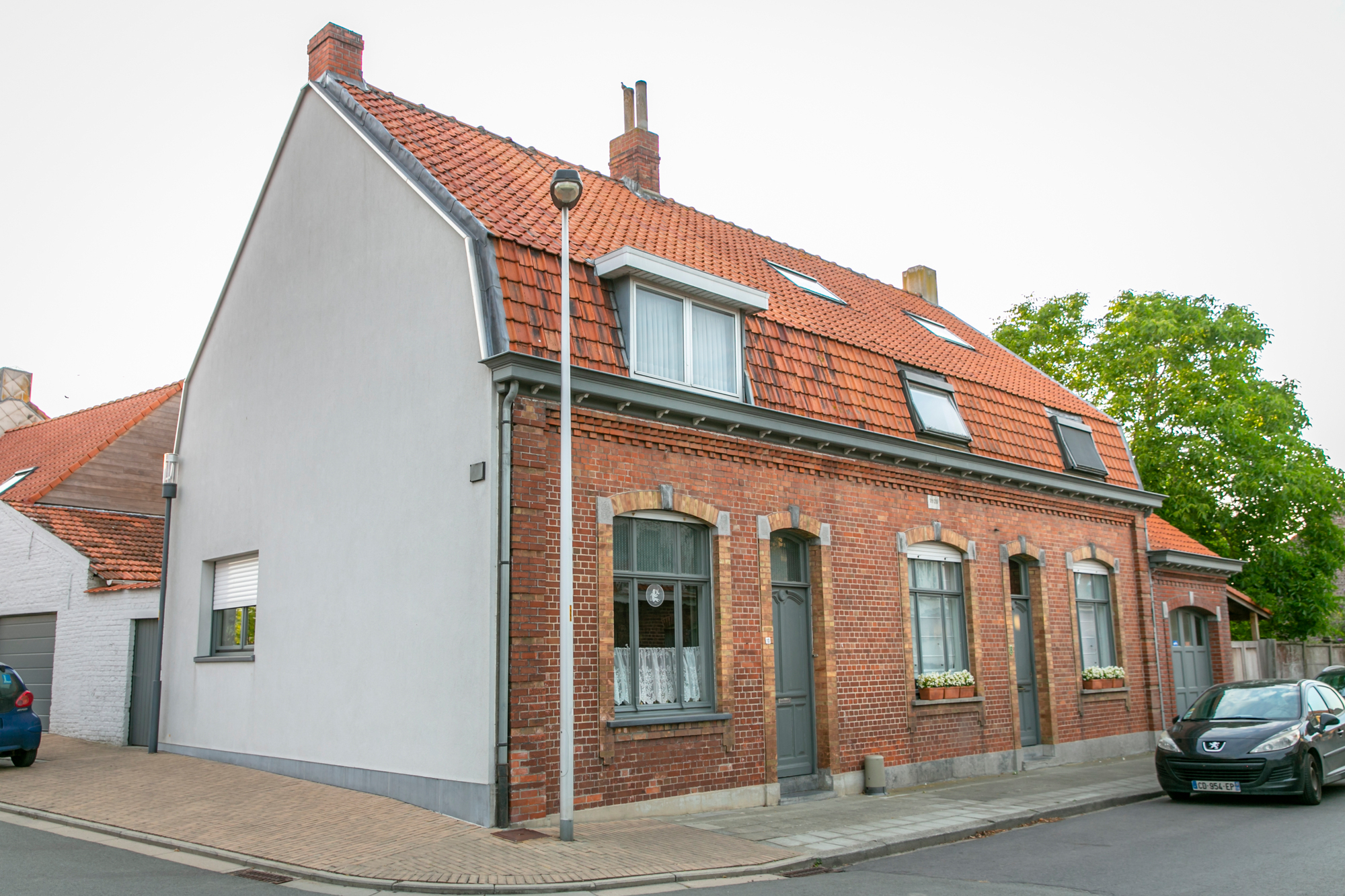 Goed onderhouden arbeiderswoningen met isolatie aan de zijgevel in Dikkebus